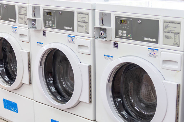 Miami, USA - September 09, 2019: industrial washing machines in a public laundromat, coin laundry service - Photo, Image