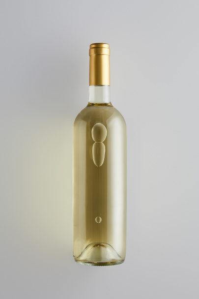 top view of bottle with white wine on white background - Φωτογραφία, εικόνα