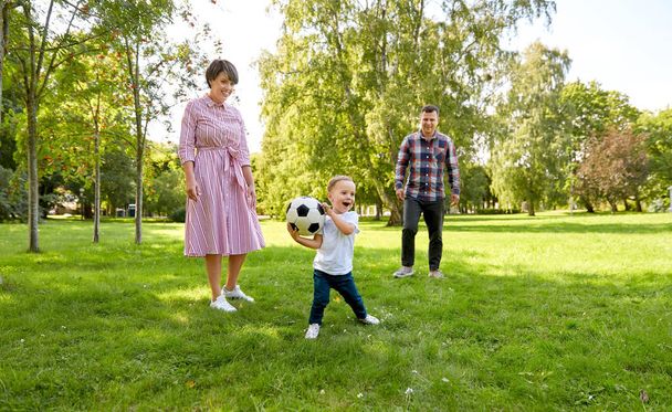 happy family playing soccer at summer park - Foto, afbeelding