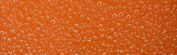 panoramic shot of clear transparent water drops on orange background - Photo, Image