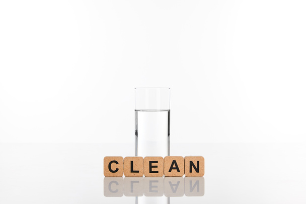 clear fresh water in glass near cubes with clean lettering isolated on white - Foto, immagini