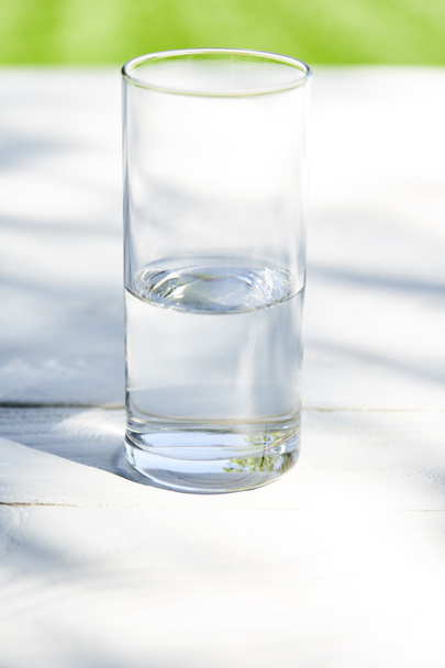 água limpa fresca em vidro transparente no dia ensolarado na mesa de madeira
 - Foto, Imagem