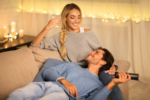 Mladí manželé si užívají zimních prázdnin, mluví a sledují televizi - Fotografie, Obrázek