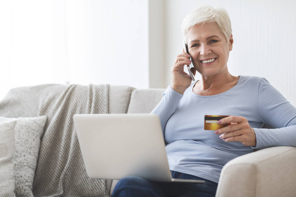 Зрелая женщина делает покупки онлайн с кредитной картой и ноутбуком
 - Фото, изображение
