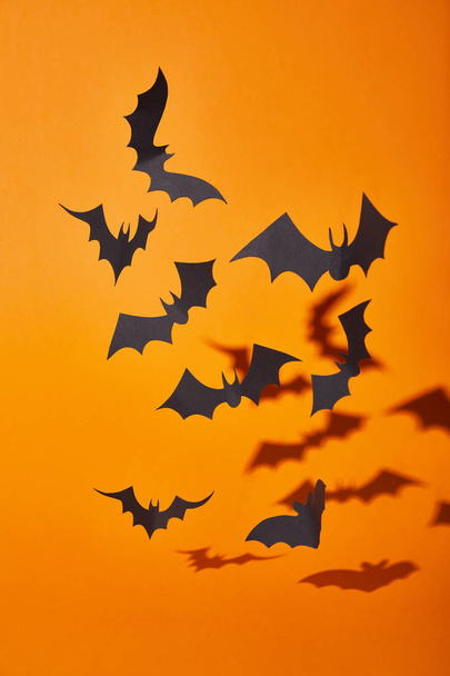 paper bats with shadow on orange background, Halloween decoration - Φωτογραφία, εικόνα
