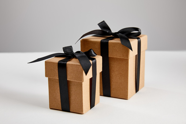 cardboard gift boxes with black ribbons isolated on grey, black Friday concept - Fotografie, Obrázek