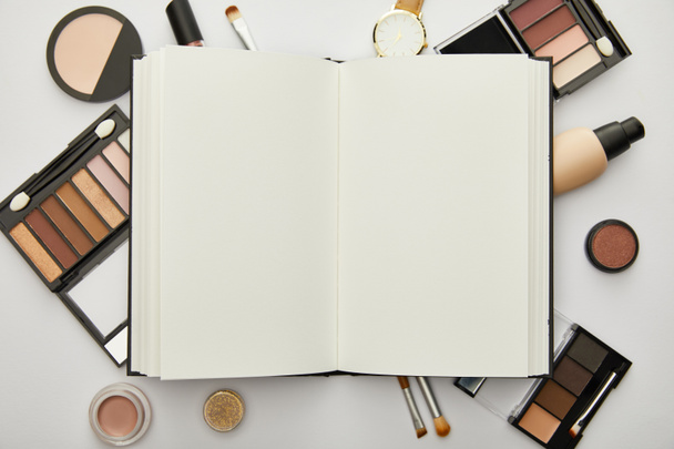 notebook közelében óra és dekoratív kozmetikumok elszigetelt szürke  - Fotó, kép