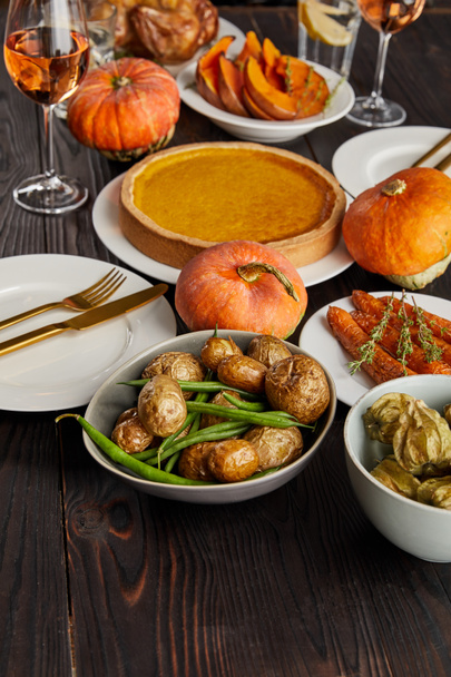 pumpkin pie, baked potatoes, pumpkins and carrots on wooden table - Photo, Image