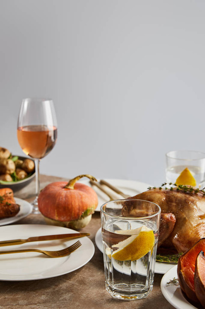 whole pumpkin near grilled turkey, and glasses with rose wine isolated on grey - Fotografie, Obrázek
