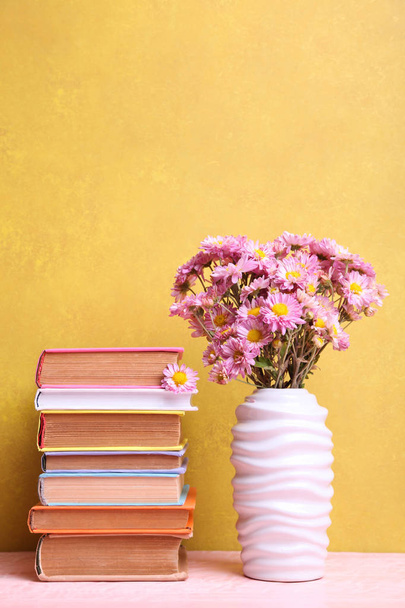 knihy a váza s kyticí chryzantémy  - Fotografie, Obrázek