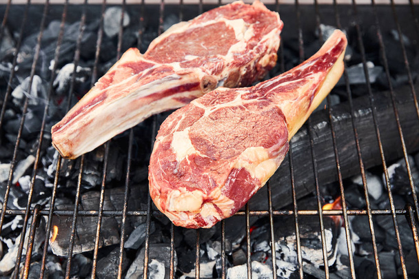 top view of raw meat grilling on barbecue grid outside  - Photo, Image