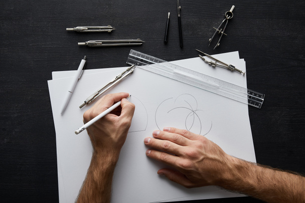 Ausgeschnittene Ansicht des Architekten Zeichenkreis auf weißem Papier mit Bleistift  - Foto, Bild