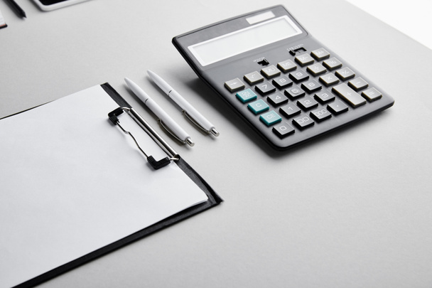 írótábla másolási hellyel, tollakkal és számológéppel az asztalon  - Fotó, kép