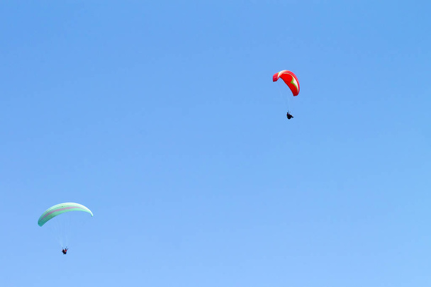 Dos coloridos parapentes volando en el cielo azul claro
  - Foto, Imagen