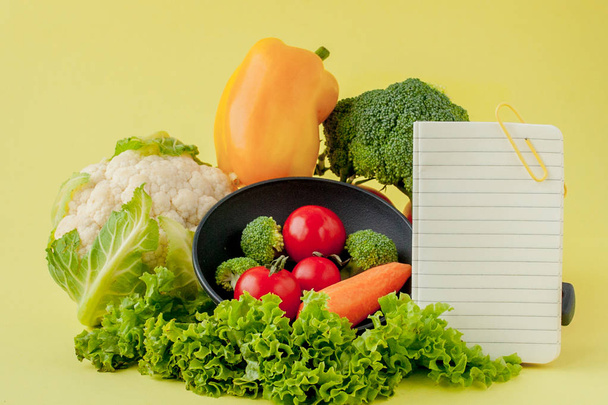 Sarı arka planda kopya alanı olan sebzeler ve defter. Bio Sağlıklı gıda, sarı arka plan üzerinde Organik sebzeler - Fotoğraf, Görsel