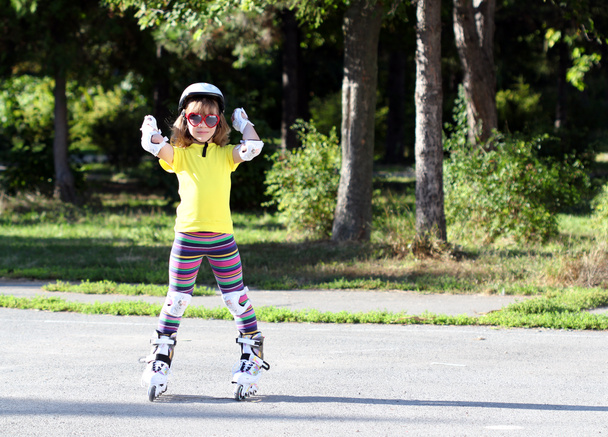 防護服とローラー スケート少し幸せな女の子 - 写真・画像