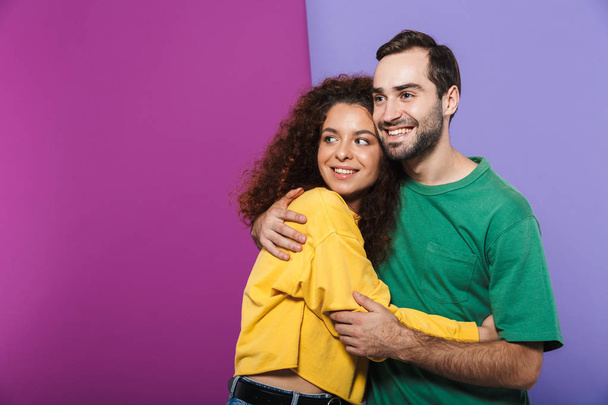 Portrait of content caucasian couple in colorful clothing smilin - Фото, зображення