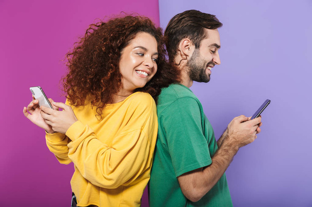 Portrait of optimistic caucasian couple in colorful clothing smi - Foto, afbeelding