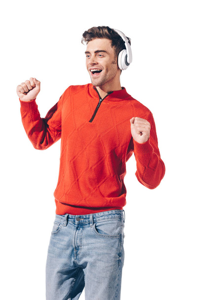 cheerful man dancing while listening music with headphones, isolated on white - Fotó, kép