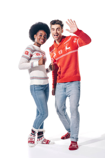casal multiétnico acenando e mostrando polegar para cima, isolado em branco
  - Foto, Imagem
