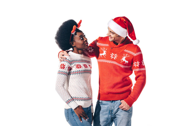 smiling interracial couple in santa hat and christmas deer horns, isolated on white - Φωτογραφία, εικόνα