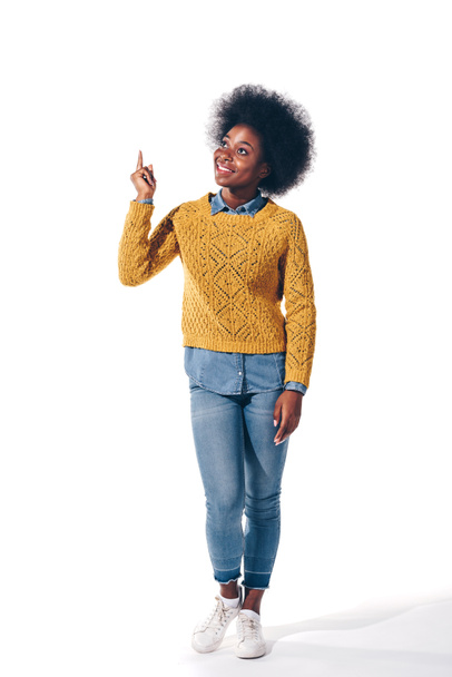 smiling african american girl in yellow sweater pointing up, isolated on white - Valokuva, kuva