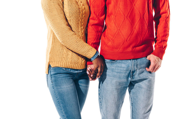 oříznutý pohled na multietnický pár držící se za ruce, izolovaný na bílém  - Fotografie, Obrázek