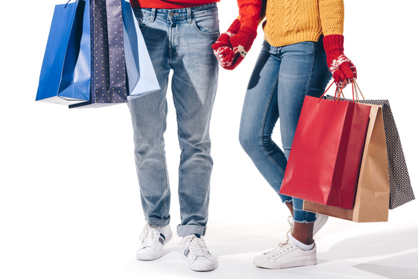 cropped view of couple with shopping bags holding hands, isolated on white - Photo, Image