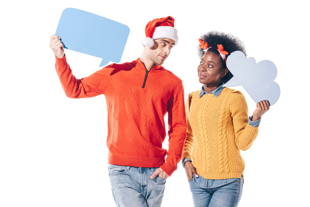 multicultural couple in santa hat and deer horns holding empty boards, isolated on white - Photo, Image