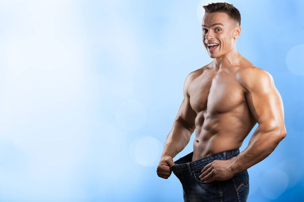 young muscular man in denim jeans, dieting concept  - Фото, зображення