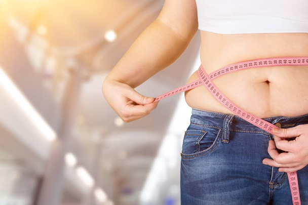 Mujer con vientre gordo sosteniendo cinta métrica
  - Foto, imagen