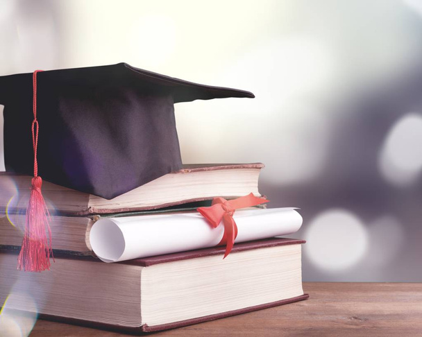 Graduation hat, books and diploma  - Fotó, kép