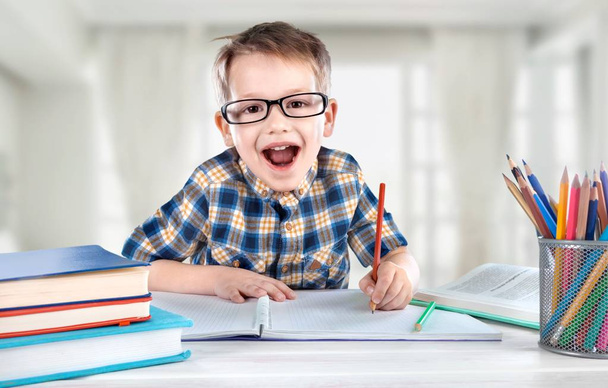 vzrušený malý chlapec dělá své domácí úkoly  - Fotografie, Obrázek