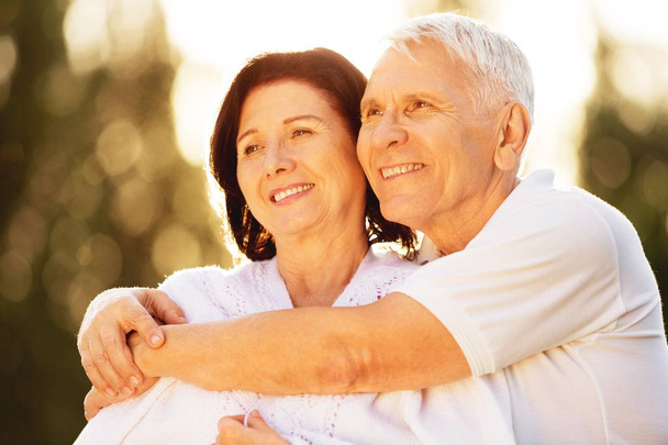 Happy senior couple smiling and hugging  - Фото, изображение