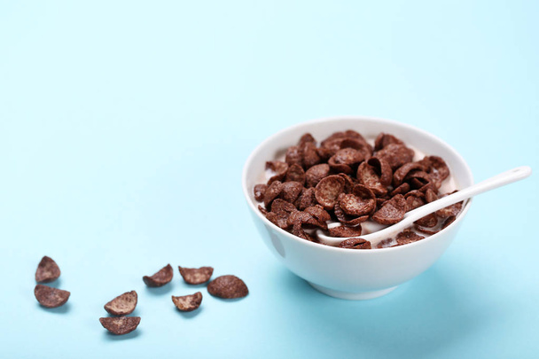 Chocolate corn flakes in bowl with milk and spoon on pink backgr - Fotoğraf, Görsel