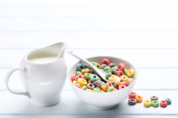 Colorful corn rings with milk in jar on wooden table - Фото, зображення
