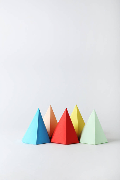 Colorful paper geometric figures on grey background - Фото, изображение
