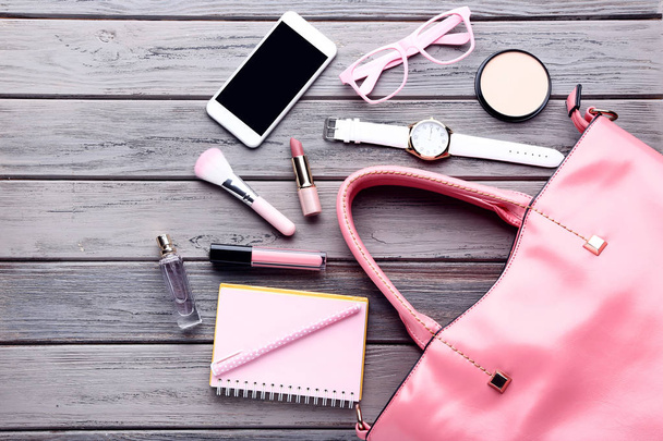 Handbag with cosmetics, smartphone, notebook and wrist watch on  - Fotografie, Obrázek