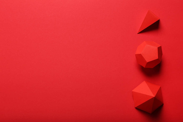 Paper geometric figures on red background - Foto, Imagem