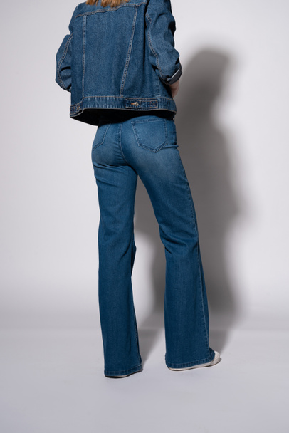 cropped view of young woman in denim jeans and jacket standing on white  - Photo, Image