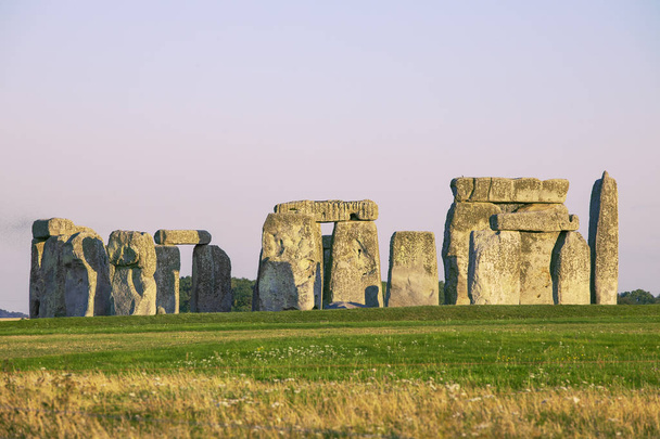 Słynne kamienie stojące Stonehenge w Wiltshire w Anglii. Światło słoneczne, czyste niebo, Zielona trawa, bez ludzi. - Zdjęcie, obraz