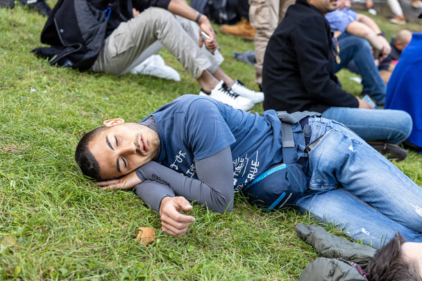 Μόναχο, Γερμανία, 2019 19 Σεπτεμβρίου: 4 άτομα κοιμούνται στη σειρά στο γκαζόν στο Βαυαρικό Oktoberfest στο Μόναχο - Φωτογραφία, εικόνα