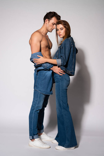 muscular man standing with attractive young woman on white  - Photo, Image