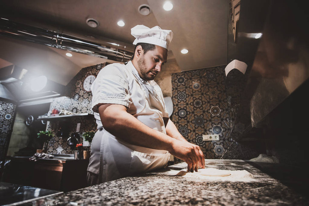 Chef está haciendo pizza en la cocina del restaurante
 - Foto, imagen