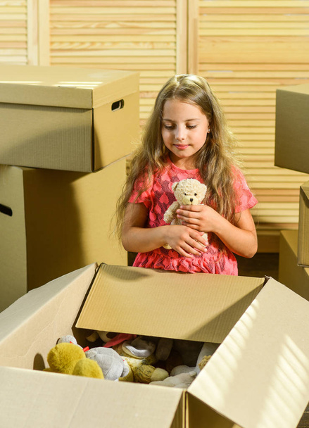 Packaging things. Move out concept. Stressful situation. Divorce and separation. Family problem. Prepare for moving. Moving out. Moving routine. Only true friend. Girl child play with toy near boxes - Zdjęcie, obraz