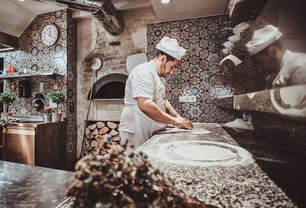 Ο σεφ φτιάχνει πίτσα στην κουζίνα του εστιατορίου - Φωτογραφία, εικόνα