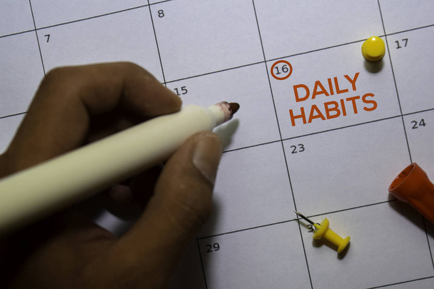 Text über die täglichen Gewohnheiten auf weißem Kalenderhintergrund. Erinnerung oder Terminkonzept - Foto, Bild