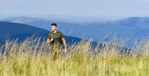battle field. man ready to fire. hunter hobby. army forces. sniper reach target mountain. muscular man hold weapon. purpose and success. soldier in the field. polygon. military male in camouflage - Fotografie, Obrázek