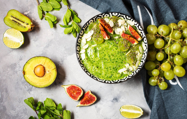 Green smoothie bowl on stone or concrete background. - 写真・画像