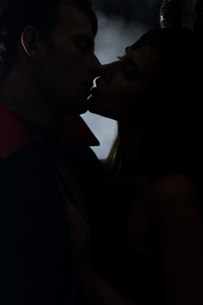 silhouette of man and woman kissing on black with smoke  - Foto, Imagen